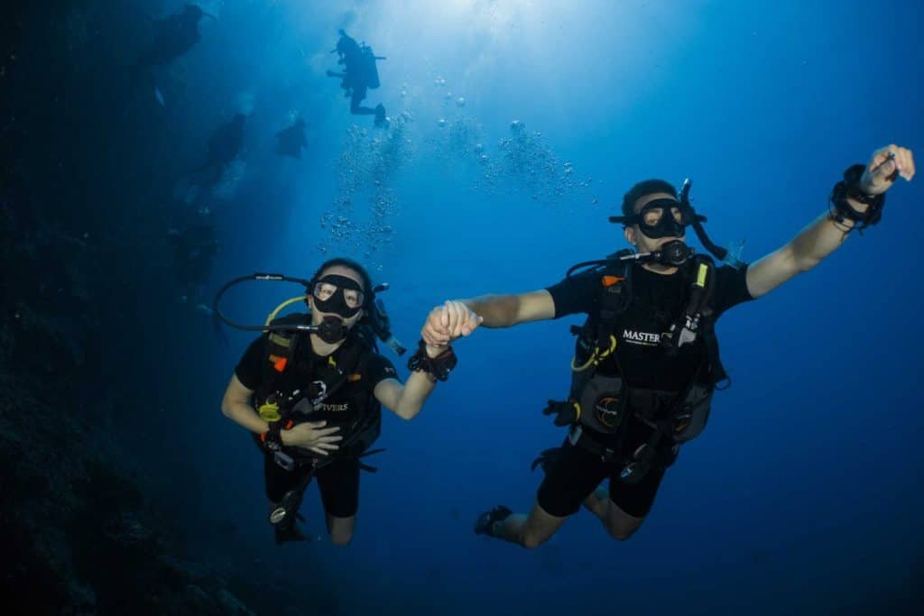 buddy-team-diving-holding-hands