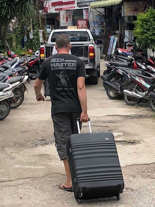 man-rolling-a-suitcase-thailand