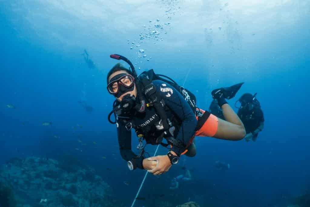 smiling-female-diver-with-group-in-the-background